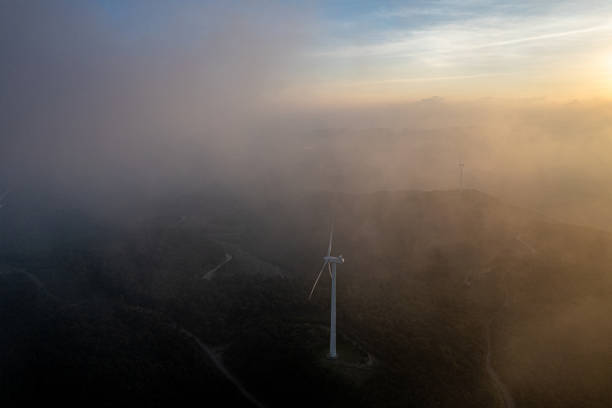 At dusk, wind turbines in the clouds and mist on the mountaintop