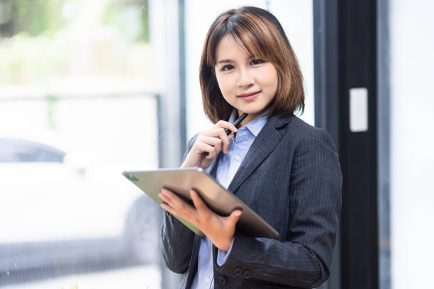 istock Attractive  Asian businesswoman using tablet and working at desk in office. 2155368316