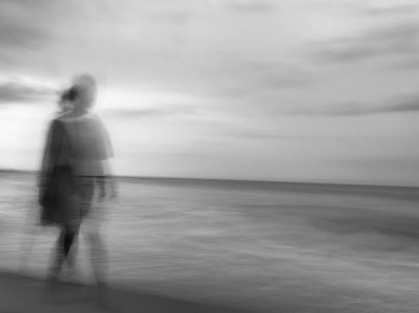 istock Silhouette of a person walking in the beach 2155369242