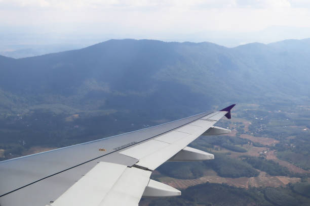 istock Image view from aircraft window show airplane wing flying with panoramic aerial view of landscape and mountain before landing. 2155369550