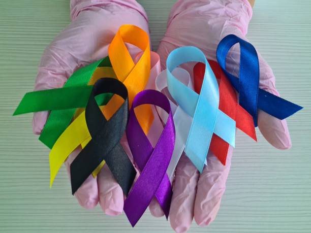 istock Gloved Hands Holding Multicolored Awareness Ribbons 2155369956