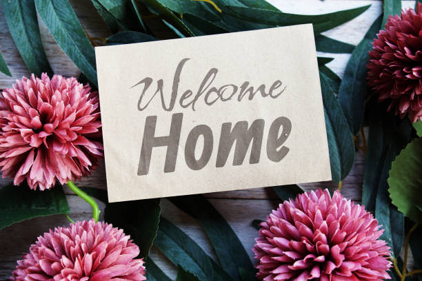 istock Welcome Home text message with flower decoration on wooden background 2155371395