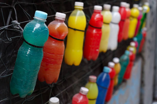 The image captures blue tethered caps on transparent plastic bottles, reflecting the environmental sustainability efforts under the EU Directive to reduce plastic waste.