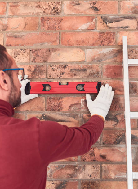 istock Handyman with spirit level working in a new home interior. 2155378931
