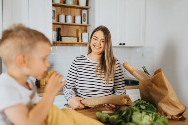 istock Mother and son organizing groceries at home 2155384228