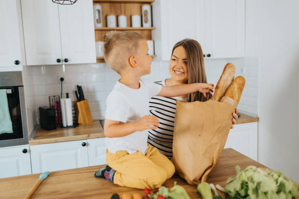 istock Mother and son organizing groceries at home 2155384335