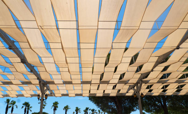 istock Transparent colored sunshade. Outdoor sunlight diffuser. White fabric awning with the palm tree background. White canvas sun 2155384458