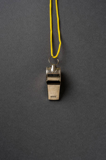 istock Top view of metal whistle with yellow string on dark gray background 2155385222