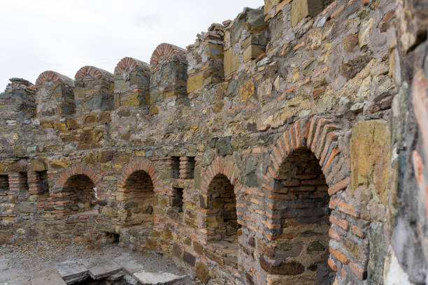 istock The wall of old tower. Bricks and stones, loopholes, visible texture. 2155388453