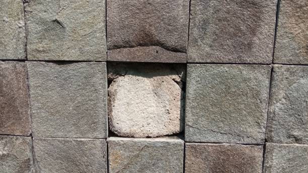 istock Wall made of square natural stones with one stone missing 2155390115