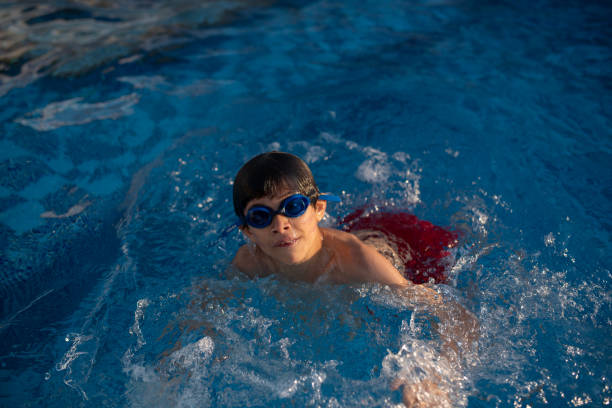 istock little boy swimming in pool in summer day 2155391763
