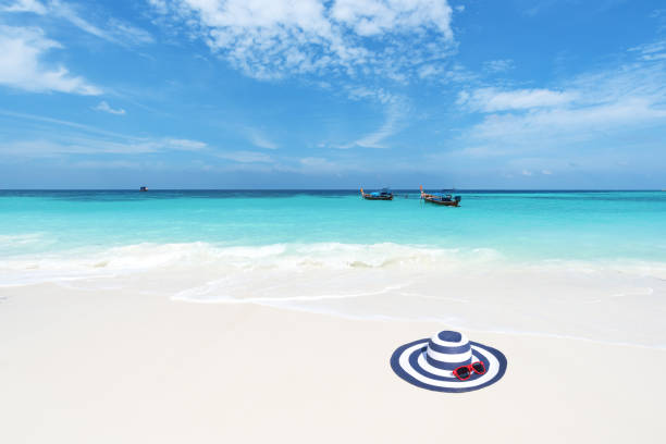 Sun hat and sunglasses on the beach -- Beach holiday concept