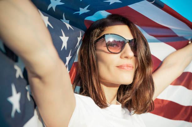 istock Independence day. Beautiful young woman under USA flag. 2155396393