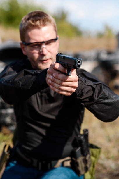 istock A man with a pistol in her hand undergoes military training at a training ground and learns to shoot. 2155397285