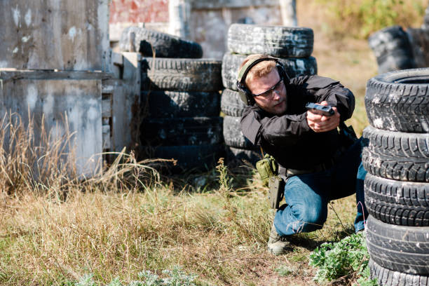 istock A man with a pistol in her hand undergoes military training at a training ground and learns to shoot. 2155397388