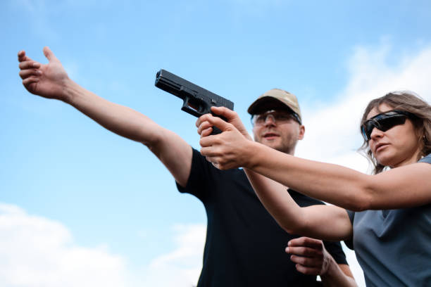 istock A weapons instructor teaches a girl to shoot a pistol at a firing range 2155397606