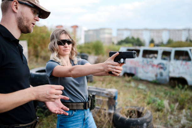 istock A girl learns to shoot a pistol at a shooting range with an instructor 2155397657