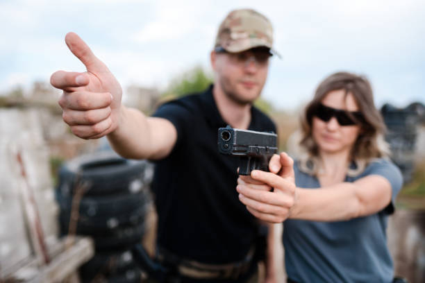 istock A weapons instructor teaches a girl to shoot a pistol at a firing range 2155397732