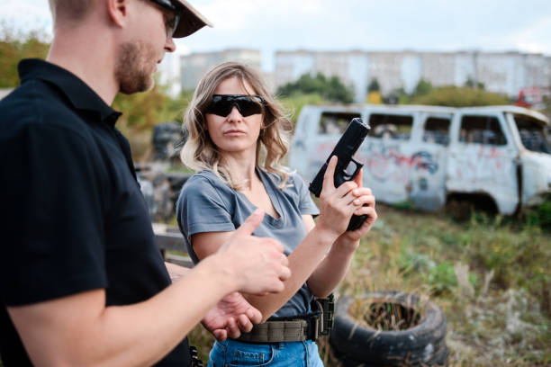 istock A weapons instructor teaches a girl to shoot a pistol at a firing range 2155397746