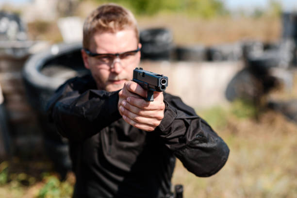 istock A man with a pistol in her hand undergoes military training at a training ground and learns to shoot. 2155398491