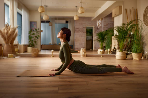istock Relaxed Japanese woman in cobra pose at Yoga studio. 2155398788