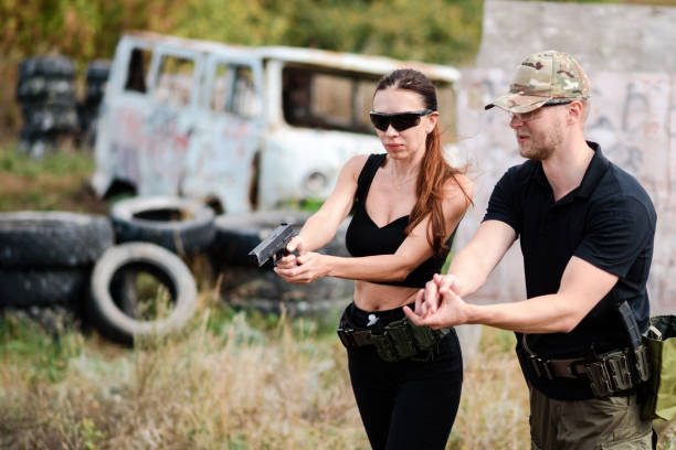 istock A weapons instructor teaches a girl to shoot a pistol at a firing range 2155398967