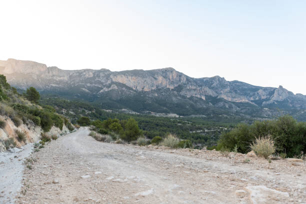 istock Gravel road through mountain range - stock photo 2155400930