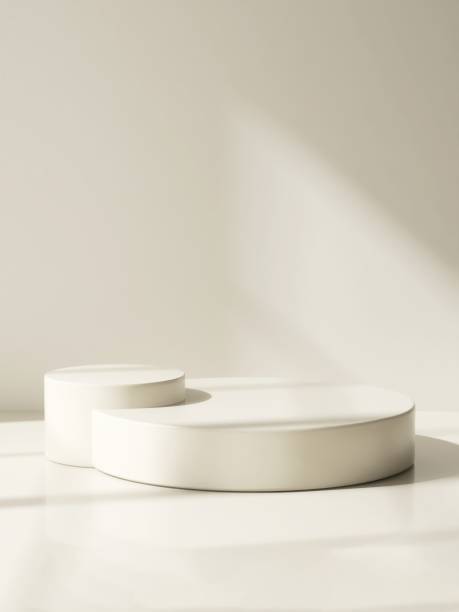 istock Two modern and minimal beige geometric round cylinder podium in sunlight, shadow on wall 2155404057