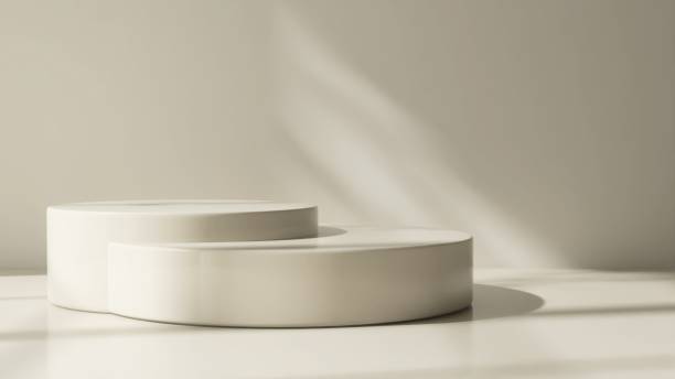 istock Two modern and minimal beige geometric round cylinder podium in sunlight, shadow on wall 2155404061