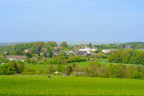 istock Village in a green meadow below a blue sky in spring 2155405626