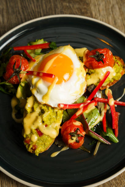 istock Top down of Avocado toast with fried eggs and vegetables 2155408111