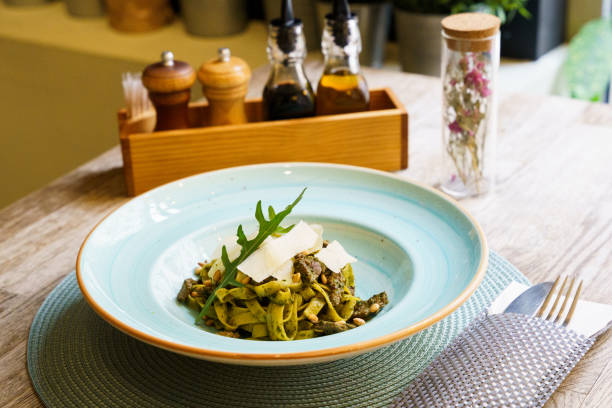 Pasta with pesto sauce and thin slices of cheese