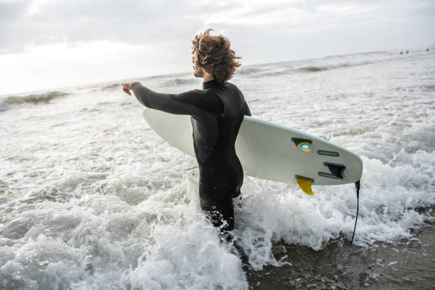 istock Male surfer s walking toward the water. 2155411605