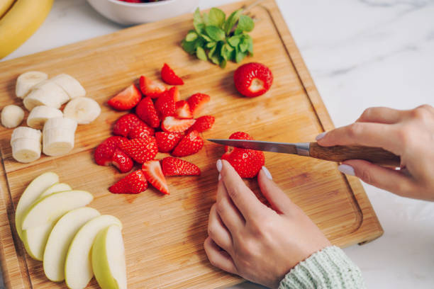 istock Woman slicing strawberries on a cutting board 2155414392
