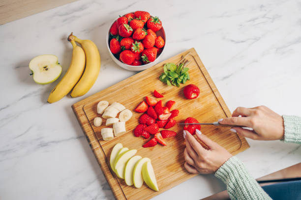 Woman slicing strawberries on a cutting board