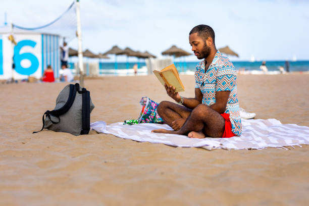 Relaxing beach day: A man lounging on a chair with his phone.