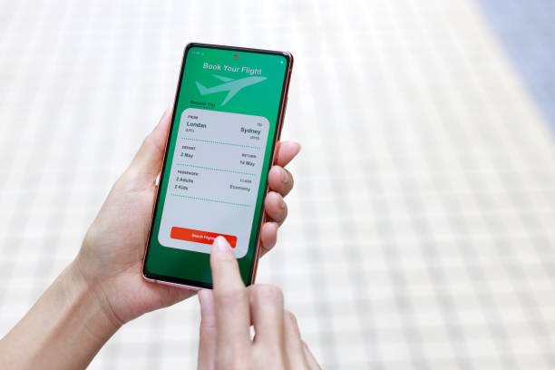istock High angle view captures a woman using a smartphone application to book flight tickets and plan her holiday trip. 2155417160