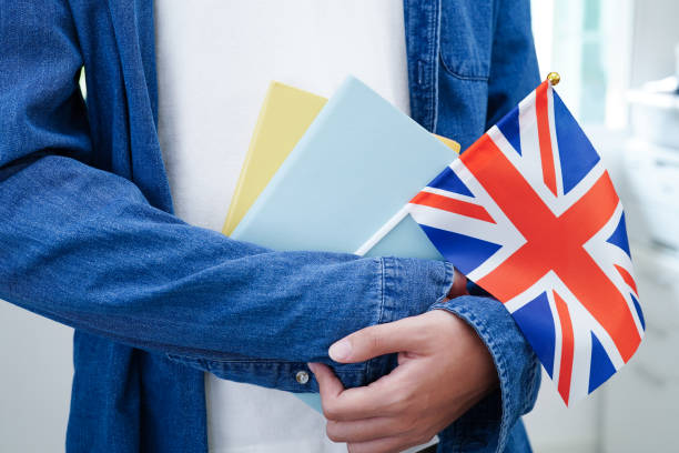 istock Learning English, Asian teenage student holding book with flag for language program education. 2155418511