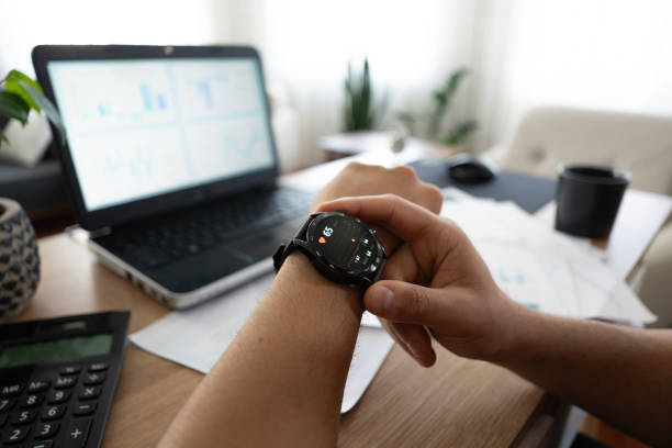 istock Close-up Young man working from home checking his pulse on his smart watch 2155427640