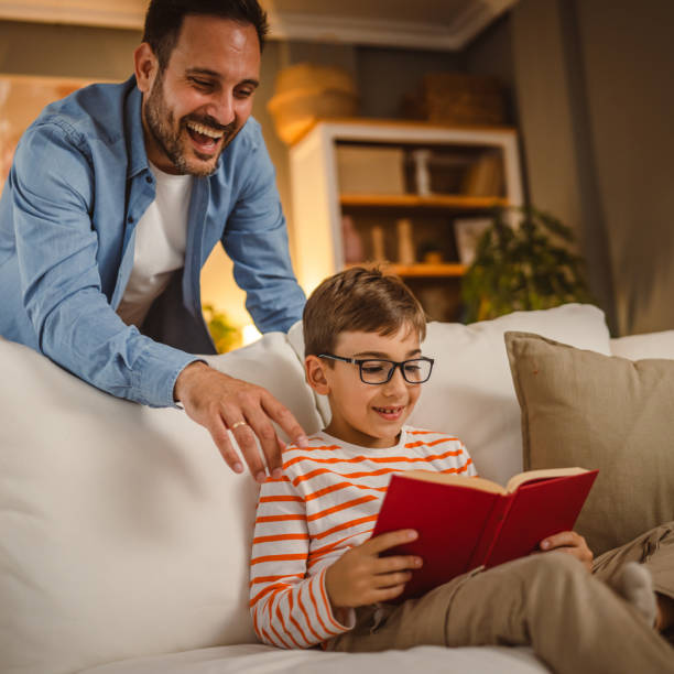 istock Father look at his son how read a book and spend time together at home 2155429280