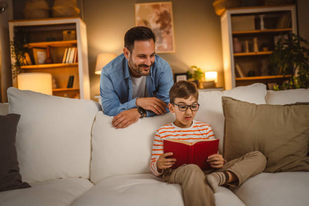 istock Father look at his son how read a book and spend time together at home 2155430127