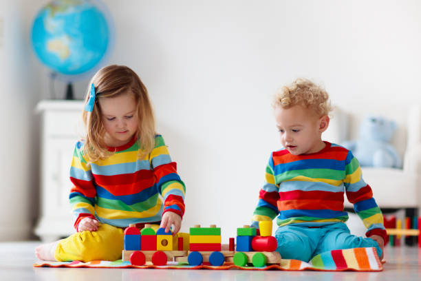 istock Kids playing with wooden toy train 2155432094