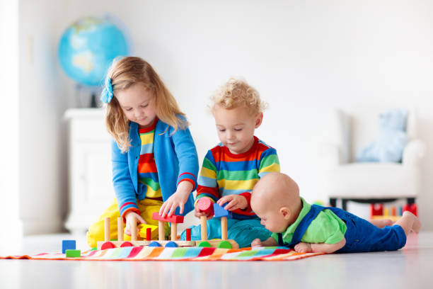 istock Kids playing with wooden toy train 2155432327