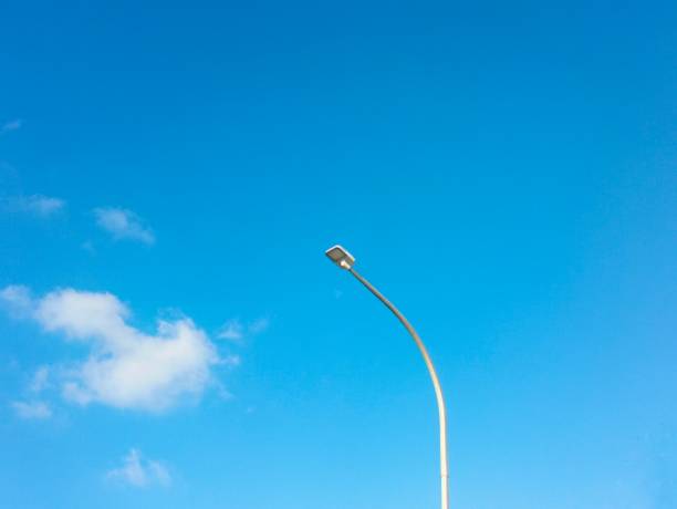 street lamp post with blue sky and clouds background
