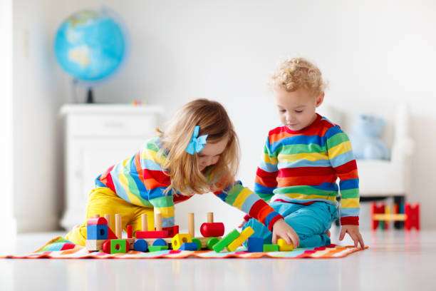 istock Kids playing with wooden toy train 2155433044