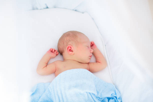 istock Little baby on white bed 2155433312