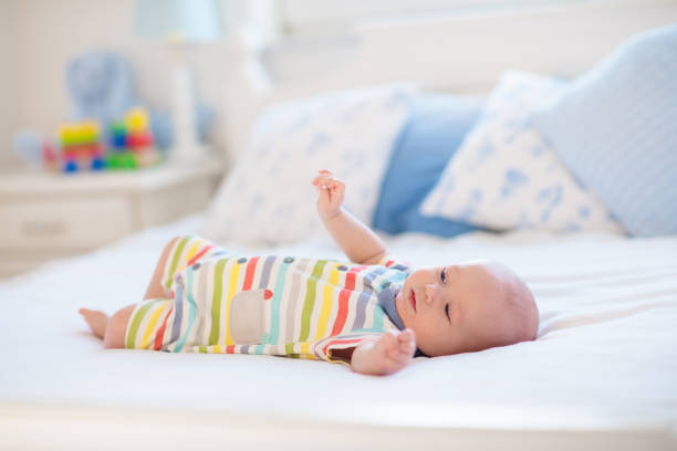 istock Little baby on white bed 2155434018