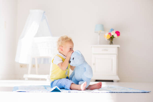 istock Little boy playing with toy teddy bear. Kids play. 2155434066