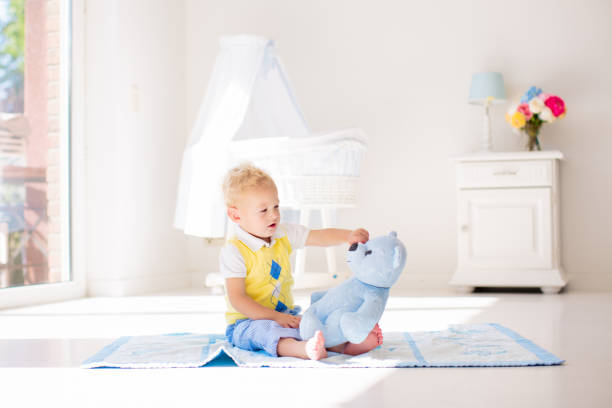 istock Little boy playing with toy teddy bear. Kids play. 2155435440