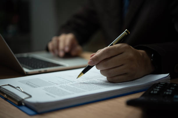 istock A man is writing on a piece of paper with a pen 2155437508